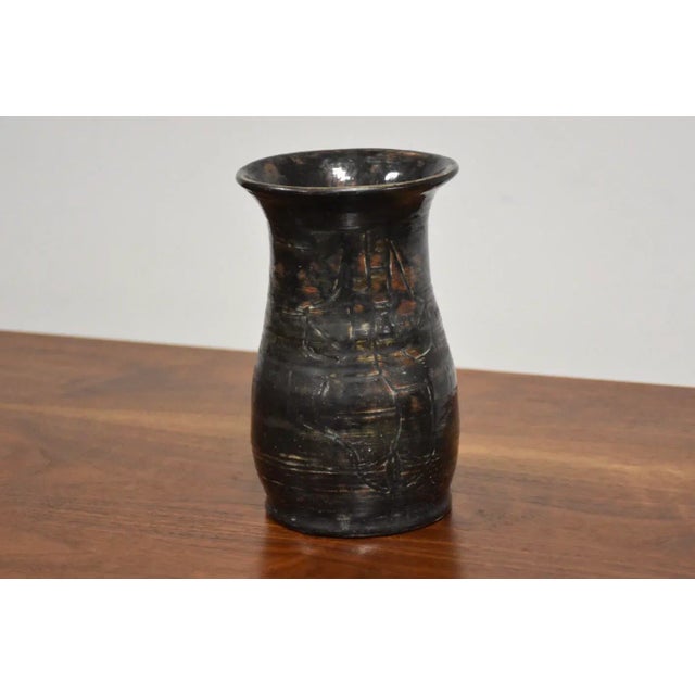 A mid century modern charcoal colored vase signed and dated with what appears to read Jealy Rolsen 1961 with a drawing of...