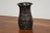 A mid century modern charcoal colored vase signed and dated with what appears to read Jealy Rolsen 1961 with a drawing of...