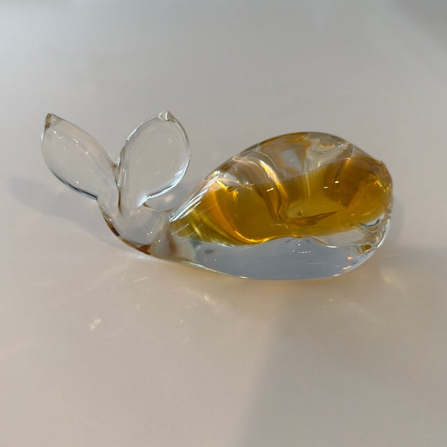 This is a vintage MCM Murano-style hand-blown glass whale paperweight featuring an amber-colored body.