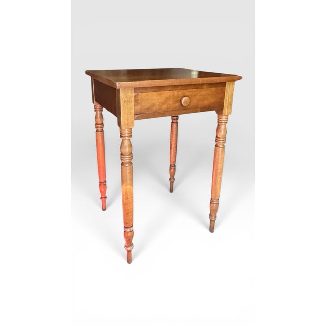 American Early 19th Century Sheraton Style Cherry Single Drawer Side Table. This Sheraton style side table features turned...