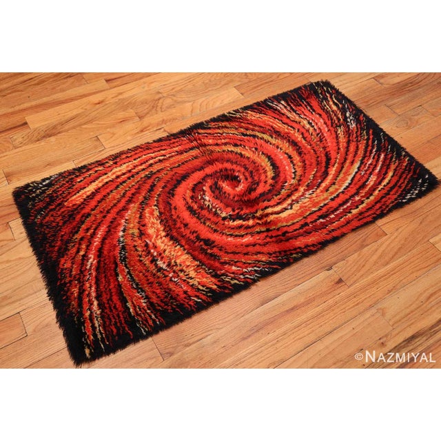 Drawn in a bold abstract style, this stunning vintage Swedish deco rug features a dramatic spiraling vortex rendered in a...