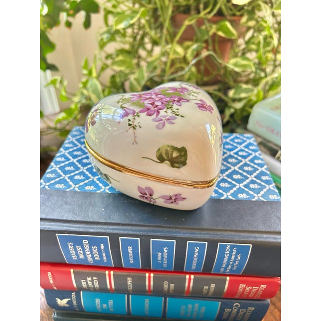A charming English bone china trinket box by Hammersley in the “Victorian Violets” pattern, featuring delicate hand-...