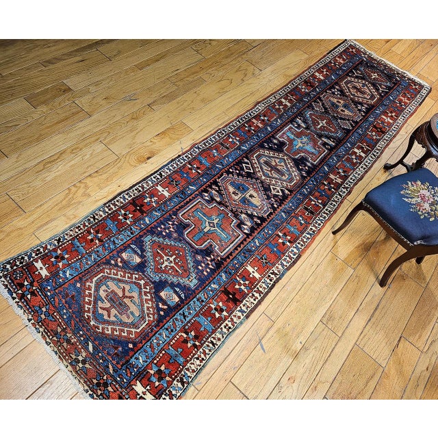 "This exquisite Persian Heriz Serapi runner, dating from the late 1800s, showcases a timeless geometric design on a...