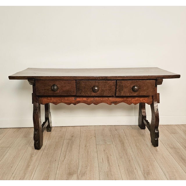 A chestnut trestle/library table, Italy or Spain circa 1720. Front shaped apron matches the drawers and legs in color. The...