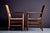 A pair of rustic armchairs with solid oak frames and hand-woven rush seats and backs, exemplifying vernacular...