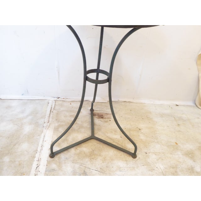 This French cafe table has weathered paint, green on the legs and gray on the top. It is 28"H x 20"D.