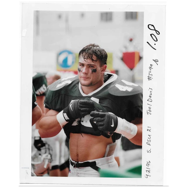 1996 color photo of football player . Publication info written in right margin identifies the photographer as Joel Davis,...