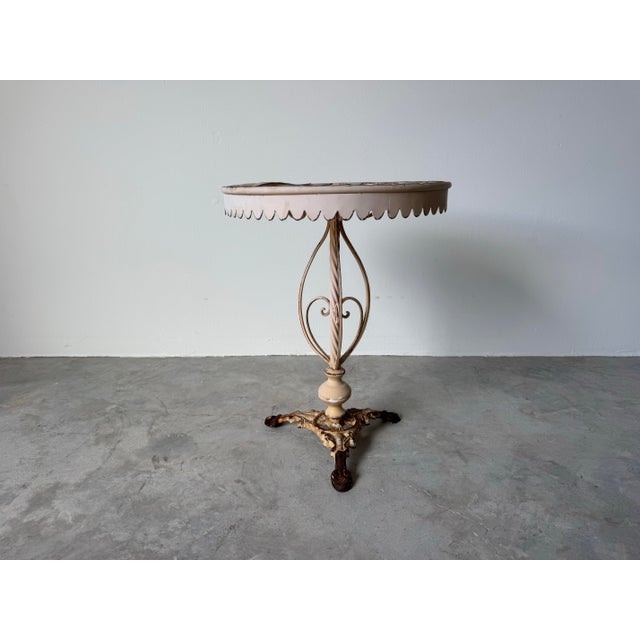 Charming and full of vintage character, this French style metal garden side table features a round top with an ornate...