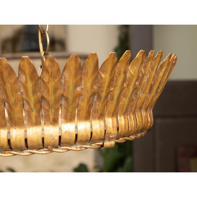 A Spanish vintage crown semi-flush gilt metal chandelier from the mid-20th century with leaf motifs, two bulbs and frosted...