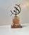 A stylish armillary sphere - sundial raised upon two architecturally shaped blocks of red/maroon onyx marble. It has a...