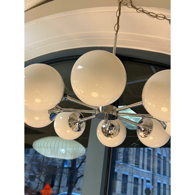 Lightolier Sputnik 8-Globe Chandelier. Eight polished chrome trumpet arms are fitted with white opaque glass globes,...