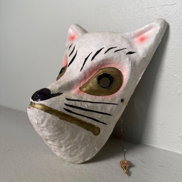 Expressive Japanese fox mask (kitsune), formed from papier-mâché based on layered washi paper and hand-painted in white,...