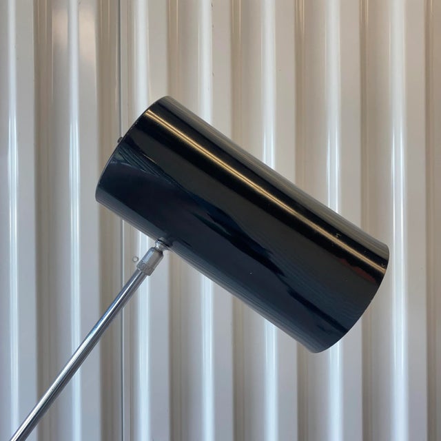 Circa 1970s chrome and black can/base cantilever floor lamp. Black metal can shaped shade that fully articulates on an...