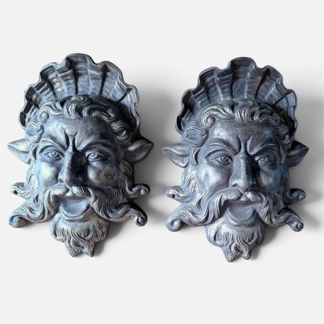 A striking, monumental pair of vintage cast iron wall plaques depicting the mythological face of Neptune (or Poseidon),...