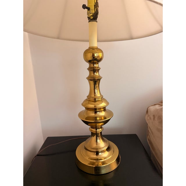 An exceptional Mid-Century Modern solid brass table lamp. This elegant luminary features signature Hollywood Regency...