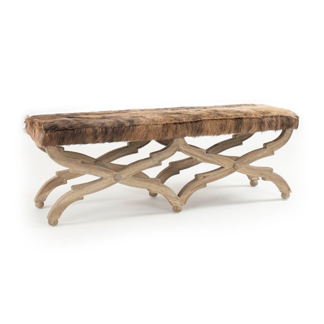 This is a bench featuring a sophisticated design with cowhide upholstery and an oak wood frame. The upholstery showcases a...