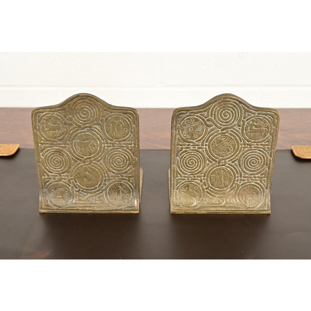 A gorgeous pair of Arts & Crafts or Art Deco period "Zodiac" pattern bronze bookends By Tiffany Studios (signed to the...
