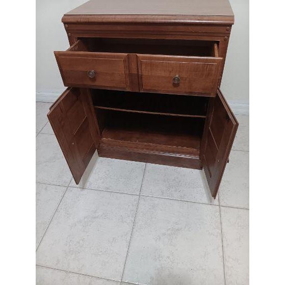 Vintage wooden storage cabinet with two small drawers above louvered shutter doors, strongly resembling mid-century...