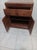 Vintage wooden storage cabinet with two small drawers above louvered shutter doors, strongly resembling mid-century...