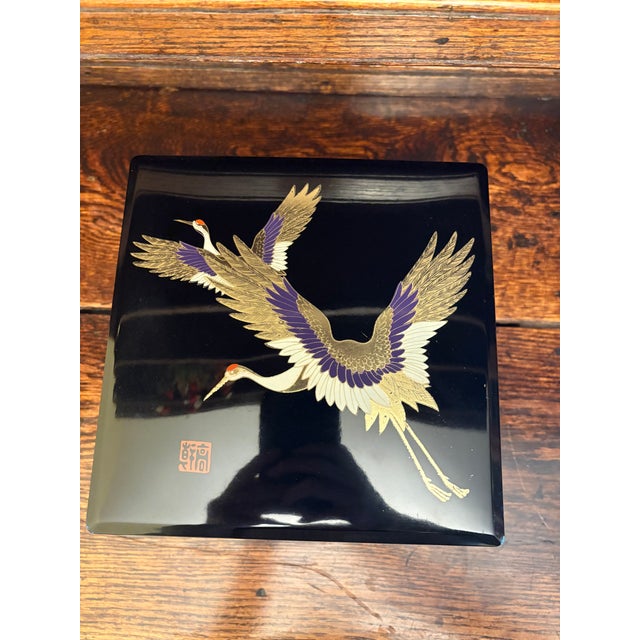 This vintage Japanese lacquerware box dates to the early-to-mid 20th century and features finely executed maki-e...