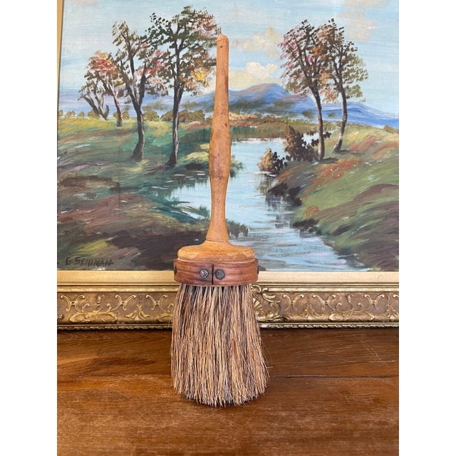 Believed to be an Early 20th-century hand broom featuring a turned solid wood handle and natural plant-fiber bristles,...
