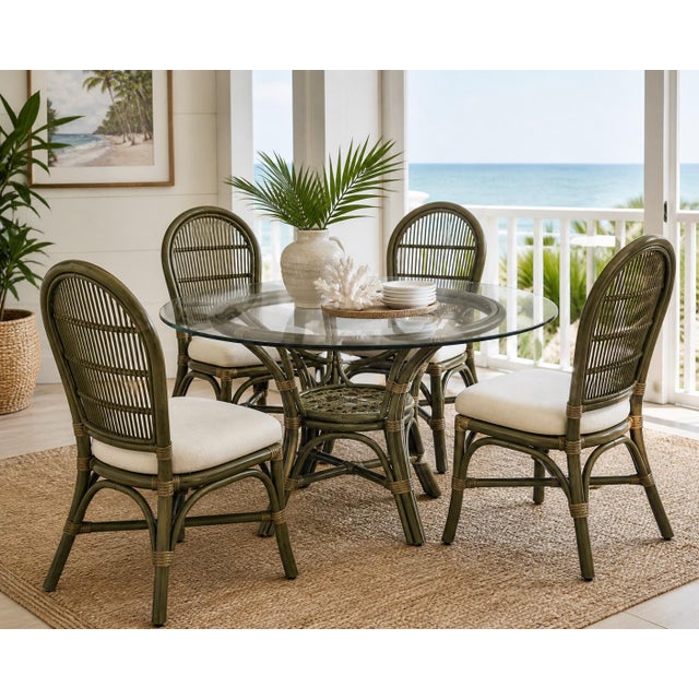 A beautifully sculpted 5-piece rattan dining set by Ritana, featuring a round glass-top table and four coordinating cane-...
