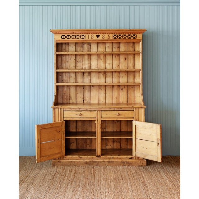 A wonderfully characterful late 19th-century country pine dresser, prominently dated 1885, combining practical farmhouse...