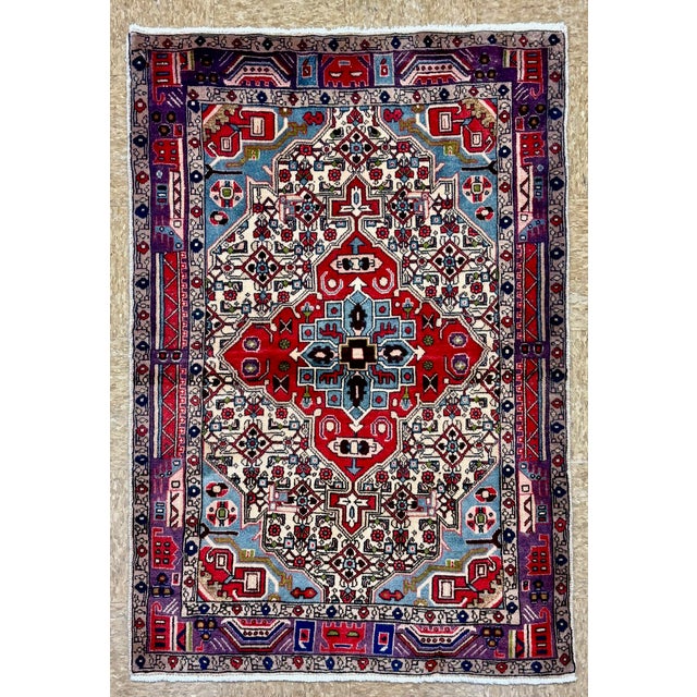 Vintage Hand-knotted village rug from the Nahavand area of western Iran, featuring a bold geometric medallion set within...