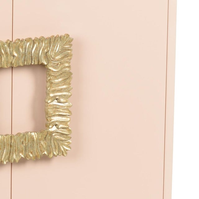 Two door cabinet with high gloss blush pink lacqured finish, antique gold leaf finish on steel base. Not intended for...