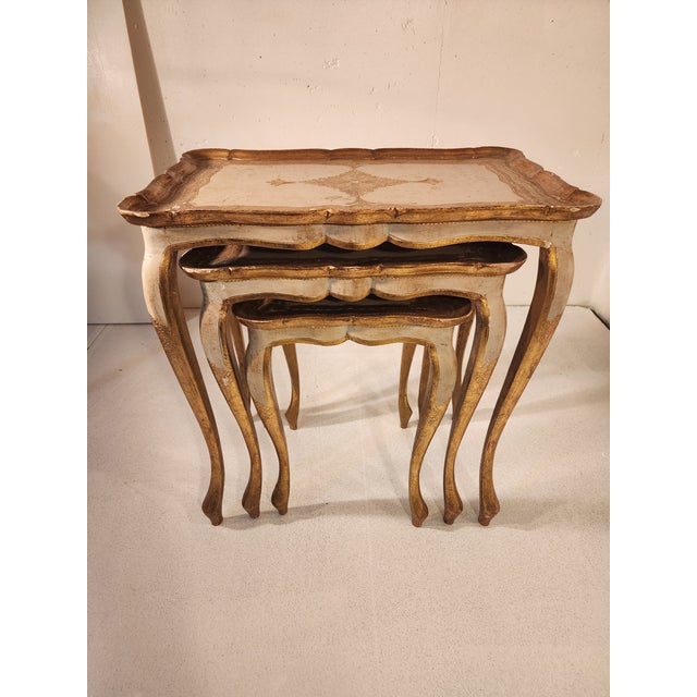 This set of three Florentine-style nesting tables was made in Italy, circa 1960. They feature cabriole legs and scalloped...