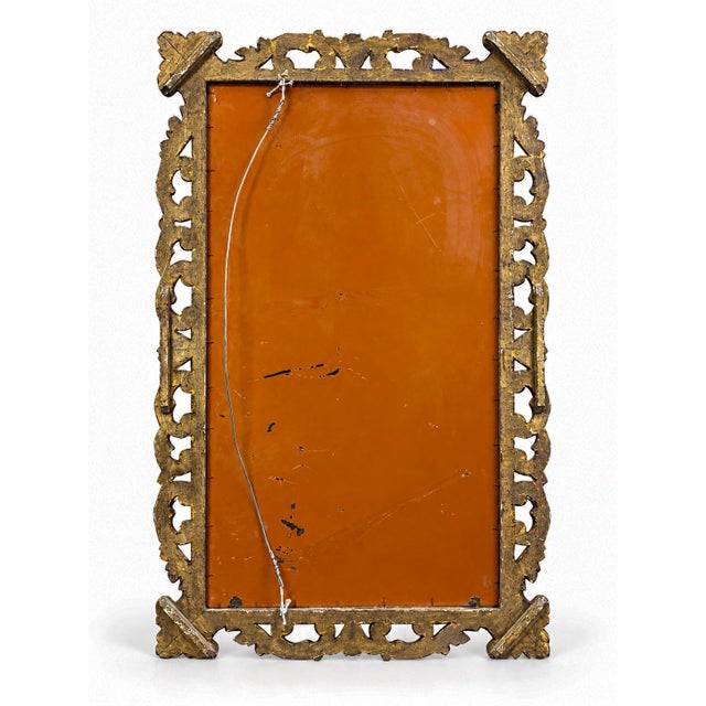 This is a late 19th century large scale Italian Rococo style gold leaf and hand carved giltwood mirror. The mirror itself...