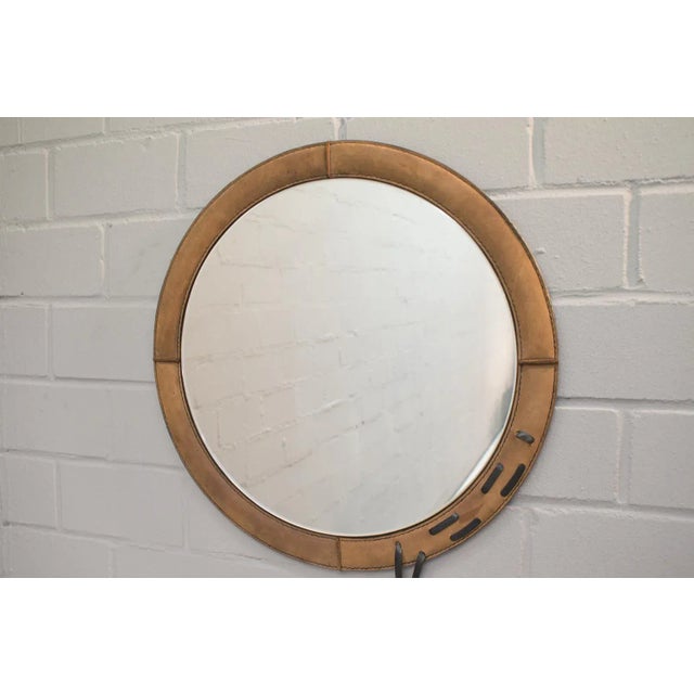 This circular suede wall mirror is from the 1960s.