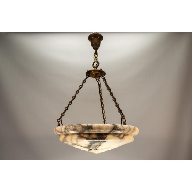 Monumental Art Deco alabaster pendant featuring dramatic veining and substantial bronze suspension. This impressive and...