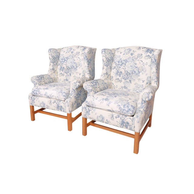 A pair of Chippendale style scrolled wingback chairs by Ethan Allen. Sculptural wings meet outward rolled arms that frame...