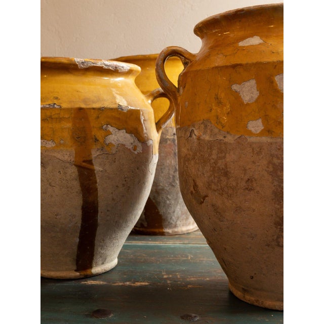 Two-handled French terracotta confit pot with an ochre-yellow glaze over the shoulder and long glaze drips down the...