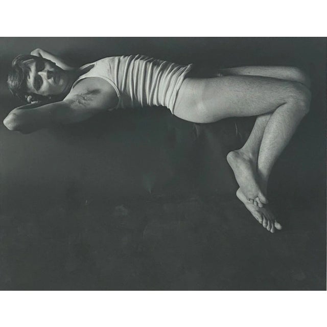 A Vintage black and white photograph of a reclining male nude by Judy Dater (1941-) untitled.