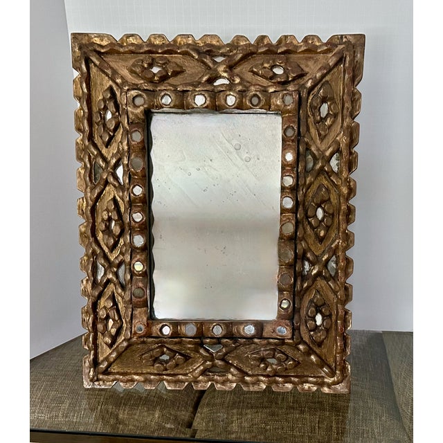 Spanish Colonial style wall mirror in dark giltwood and gesso finish, with inlaid mosaic mirror accents. Center mirror has...