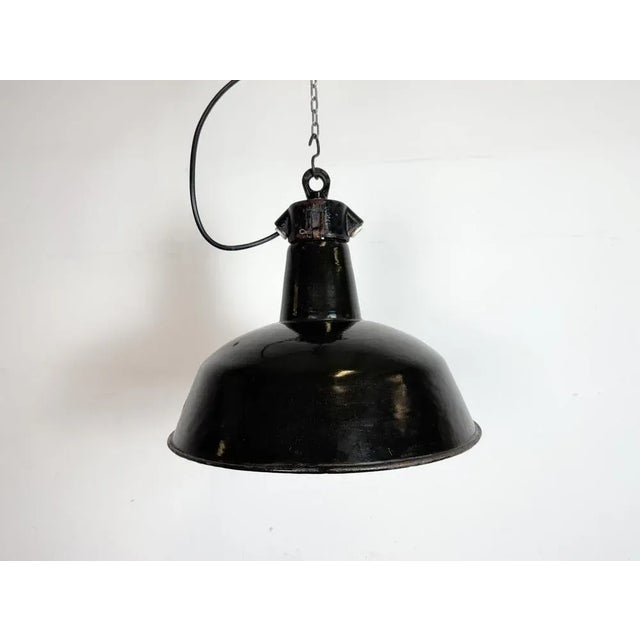 Industrial black enamel pendant light made by Elektrosvit in former Czechoslovakia during the 1950s. White enamel inside...