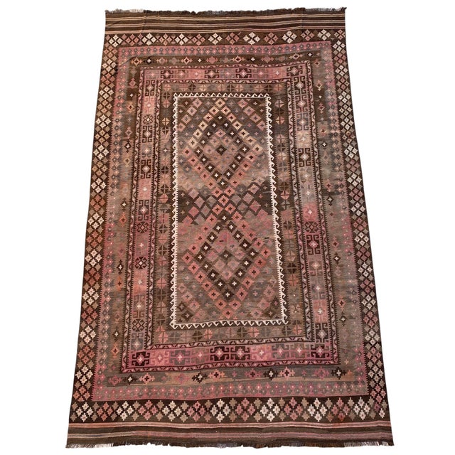 This large handwoven Afghan Maimana Ghalmori kilim is woven in warm brown, dusty rose, cream, muted gray, and soft pink...