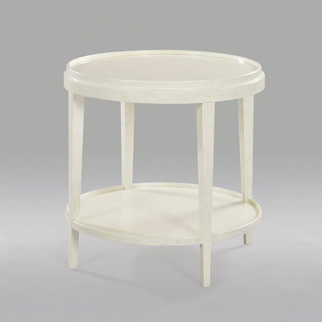 A Classic style round end table with a rustic and slightly distressed white painted finish. The two-tier side table with a...