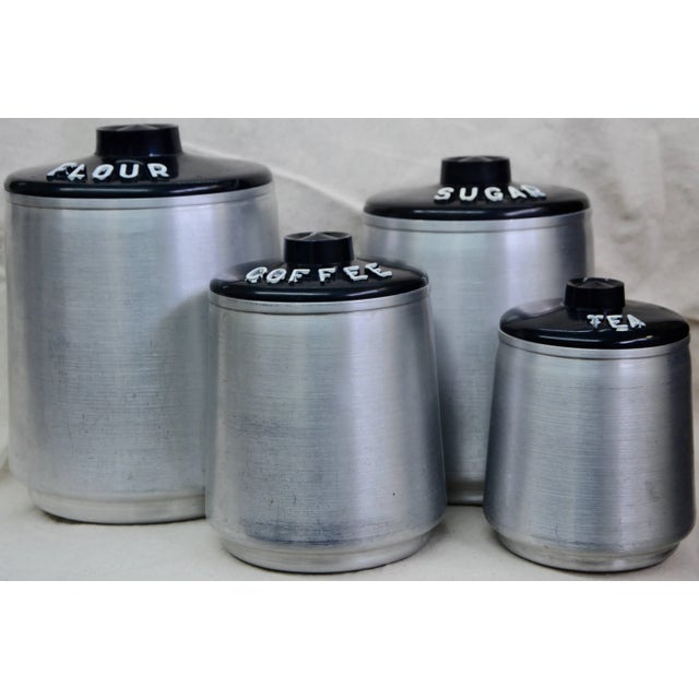 We are offering a vintage, mid-century Kromex by Alcoa brushed aluminium canister set. The canisters feature black plastic...