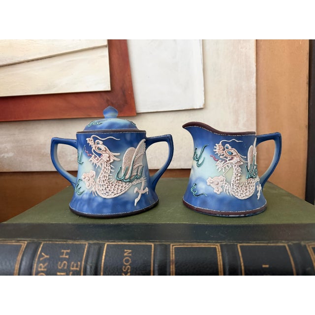 This striking vintage sugar bowl and creamer set features classic hand-painted Japanese dragonware, rendered in rich...