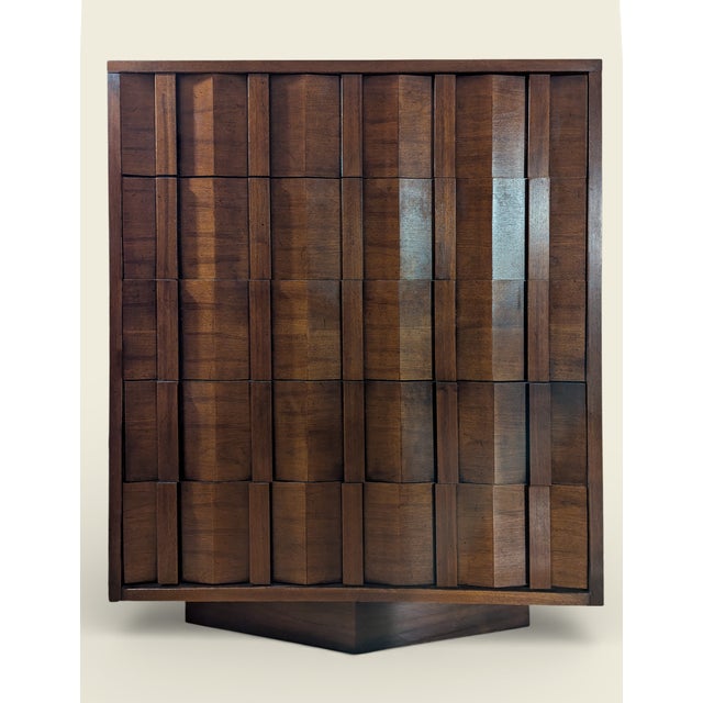 Sculptural Lane highboy dresser featuring a bold Brutalist façade with dimensional, geometric drawer fronts and a warm...