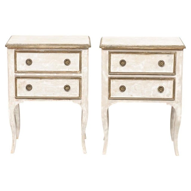 A pair of Italian painted wood, raised, two-drawer side chests from the mid 20th century. This vintage pair of end tables...