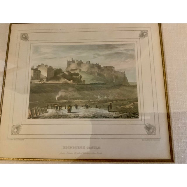 Elegant antique engraving depicting Edinburgh Castle, Scotland, presented in a decorative gilt-tone carved frame with a...