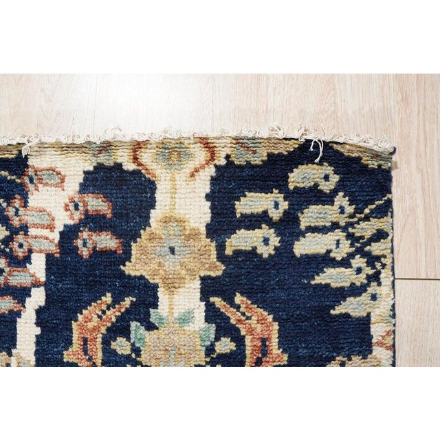 This blue wool rug features a hand knotted pile construction, drawing inspiration from traditional Agra rugs. Produced in...