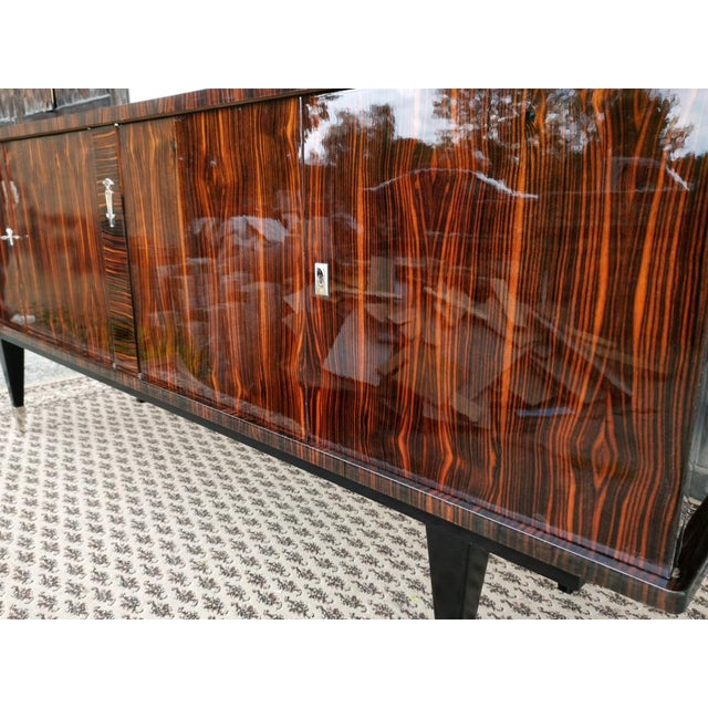 A truly spectacular and grand French sideboard from the 1960s, beautifully veneered in exotic Macassar ebony. This...