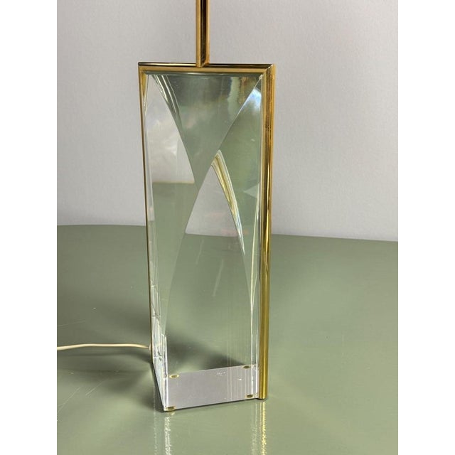 A striking and luxurious hollywood regency table lamp, featuring a substantial geometrically formed block of crystal-clear...