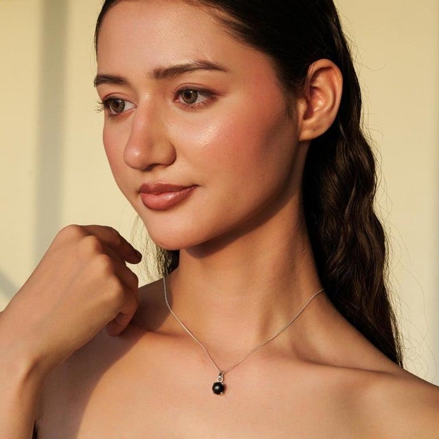 Featuring a natural 3.95 carat round Black Star gemstone, the pendant showcases a deep celestial glow with an elegant,...