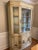 Chinoiserie china cabinet by Jasper cabinet. Features gold detailing on backdrop. Color is a very dark ivory and appears...